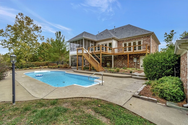 view of swimming pool featuring a wooden deck and a patio area