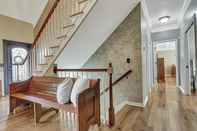 stairs featuring ornamental molding and hardwood / wood-style floors