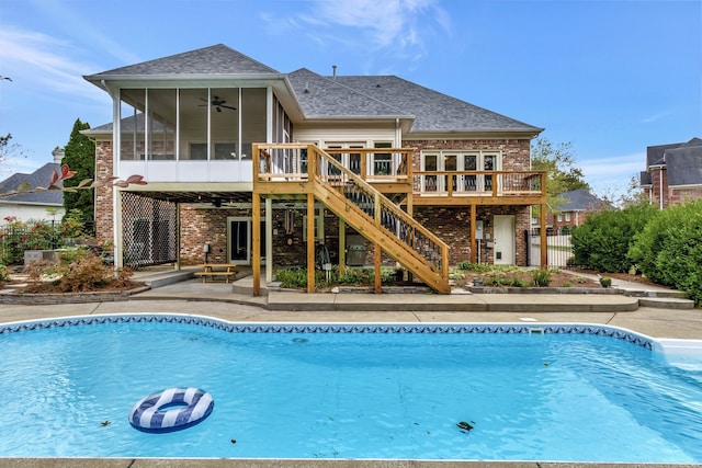 view of swimming pool featuring ceiling fan, a deck, a patio, and a sunroom