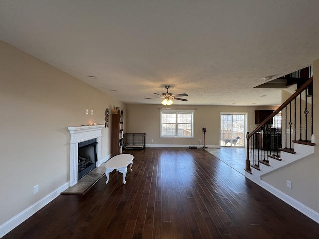 unfurnished living room featuring dark hardwood / wood-style flooring and ceiling fan