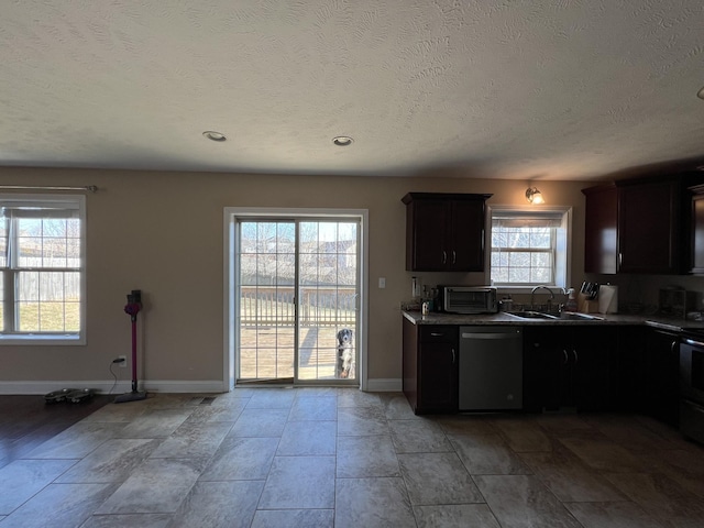 kitchen with a textured ceiling, dishwasher, a healthy amount of sunlight, and sink