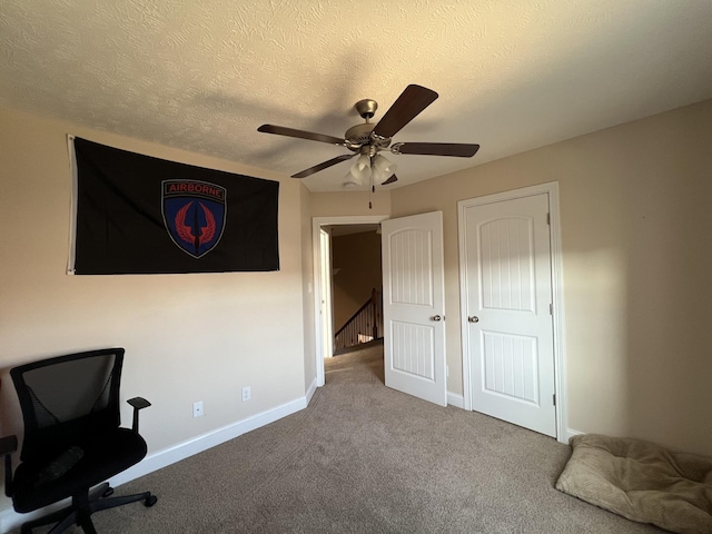 interior space featuring a textured ceiling, ceiling fan, and carpet floors