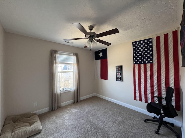 carpeted home office featuring a textured ceiling and ceiling fan