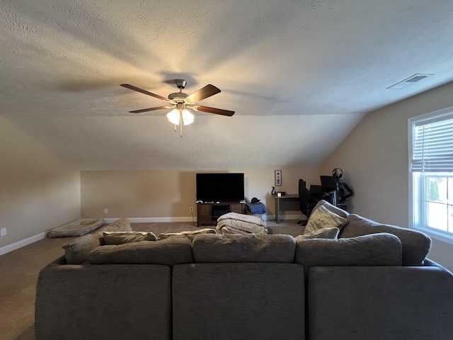 living room featuring a textured ceiling, ceiling fan, vaulted ceiling, and carpet