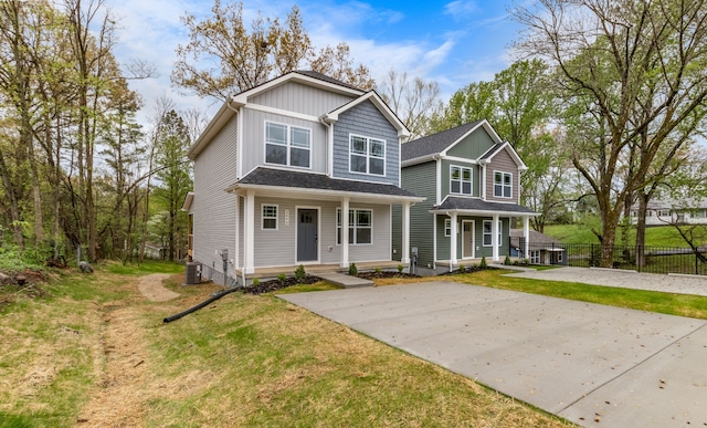 view of front facade with a front yard, cooling unit, and a porch