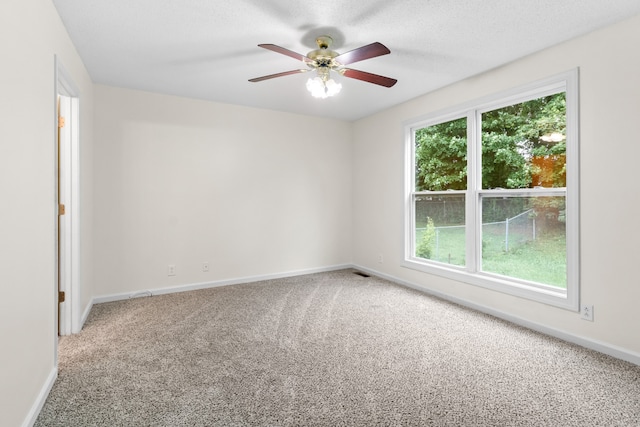 unfurnished room with a textured ceiling, carpet flooring, and ceiling fan