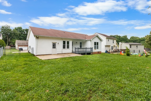 rear view of property with a yard, a deck, and a patio