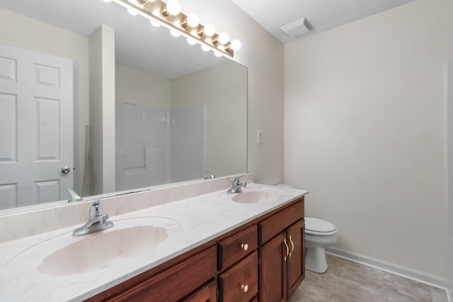 bathroom featuring vanity, toilet, and walk in shower