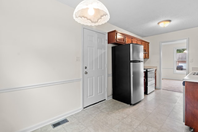 kitchen featuring white electric range, stainless steel refrigerator, a textured ceiling, and pendant lighting