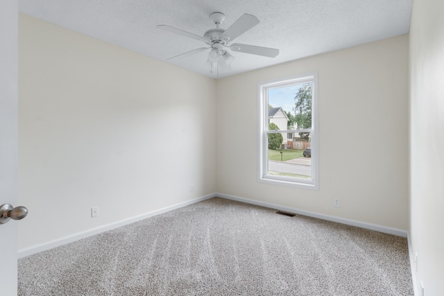 spare room featuring carpet, a textured ceiling, and ceiling fan