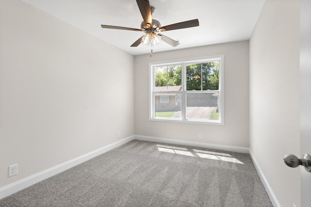 empty room featuring ceiling fan and carpet