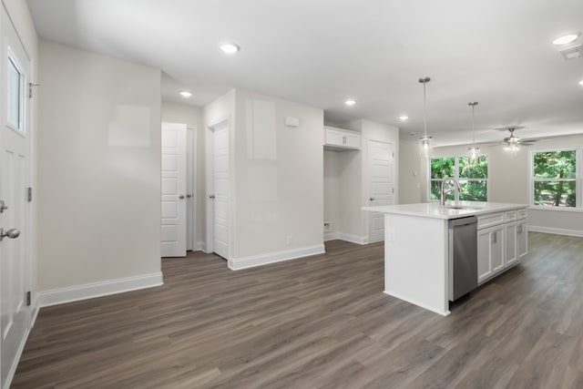 kitchen featuring dark hardwood / wood-style flooring, white cabinetry, decorative light fixtures, stainless steel dishwasher, and a center island with sink