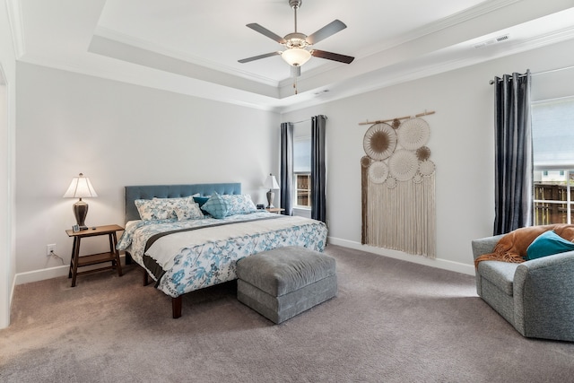 bedroom with ceiling fan, a raised ceiling, carpet flooring, and ornamental molding