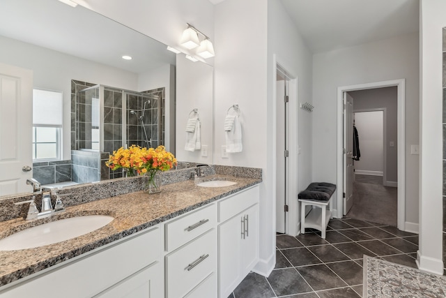 bathroom featuring vanity, a tile shower, and tile patterned flooring