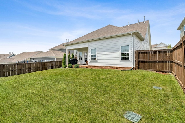 rear view of house featuring a yard