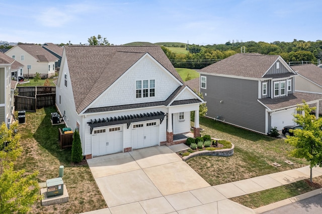 view of front of house featuring a front lawn, central AC, and a garage