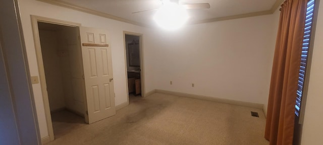 unfurnished bedroom with visible vents, light colored carpet, baseboards, and ornamental molding