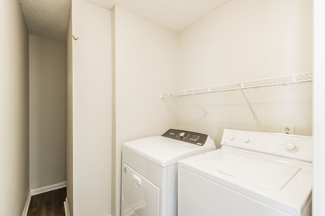 washroom with dark wood-type flooring, washer and dryer, and a textured ceiling