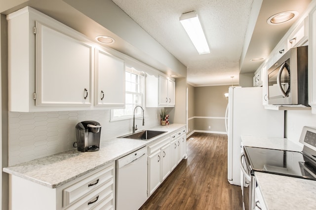 kitchen featuring sink, appliances with stainless steel finishes, white cabinetry, backsplash, and dark hardwood / wood-style floors