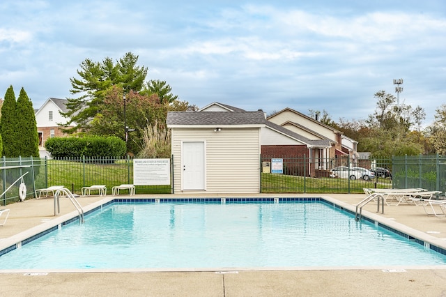 view of pool with a patio and a lawn