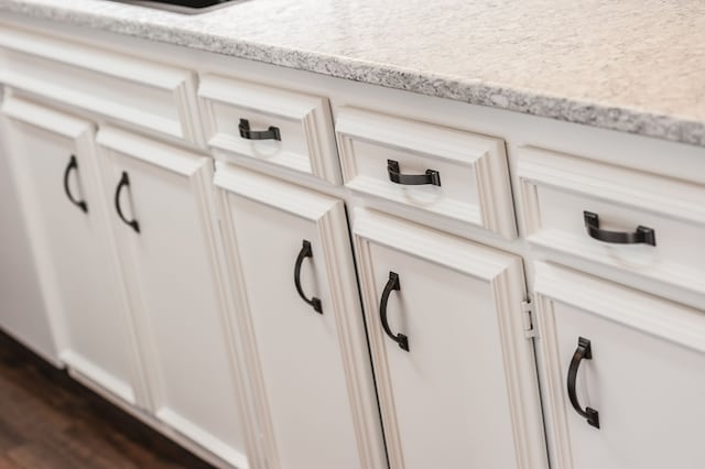 interior details featuring dark hardwood / wood-style floors and light stone counters