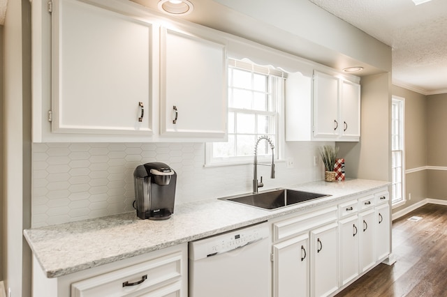 kitchen with white cabinetry, white dishwasher, sink, and tasteful backsplash