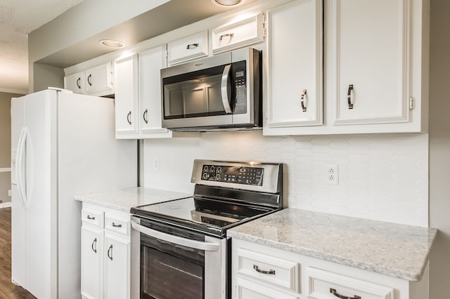 kitchen with stainless steel appliances, light stone countertops, decorative backsplash, and white cabinets