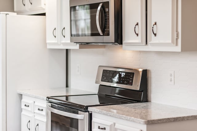 kitchen featuring white cabinetry, appliances with stainless steel finishes, and decorative backsplash