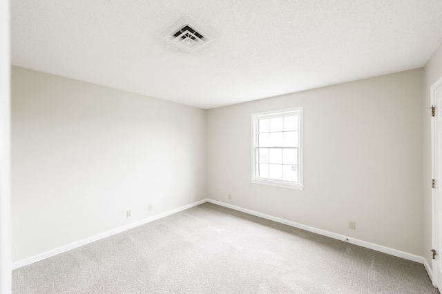 carpeted spare room featuring a textured ceiling