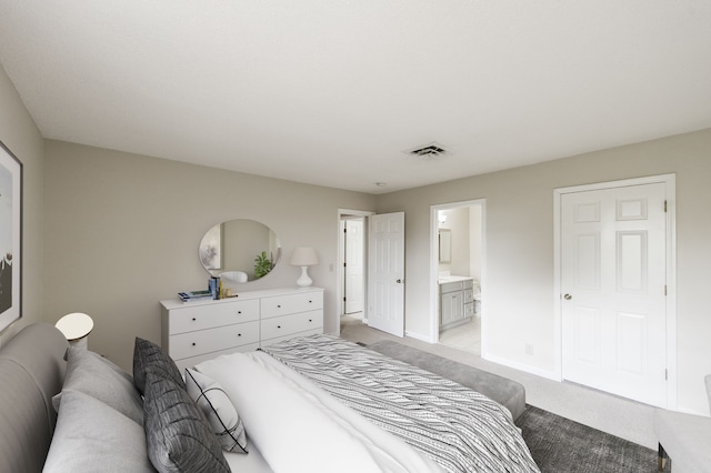 bedroom featuring ensuite bath and light carpet