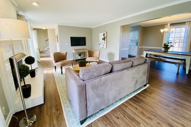 living room featuring crown molding, dark hardwood / wood-style floors, and a notable chandelier