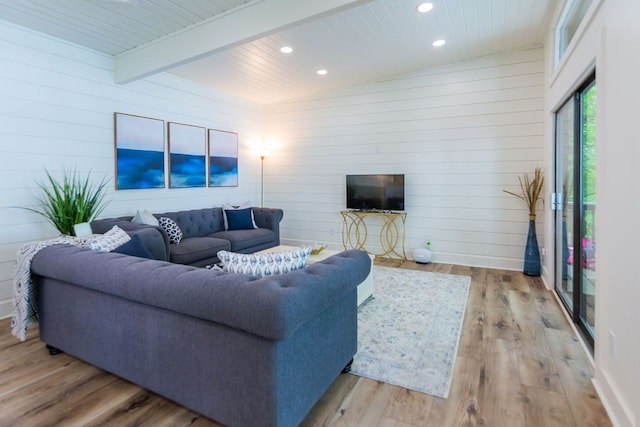 living room featuring light hardwood / wood-style flooring, vaulted ceiling with beams, wooden ceiling, and wood walls