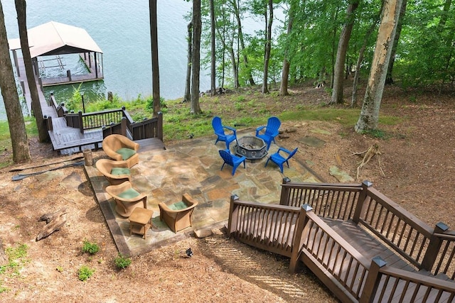 view of yard with a deck with water view, an outdoor fire pit, and a patio