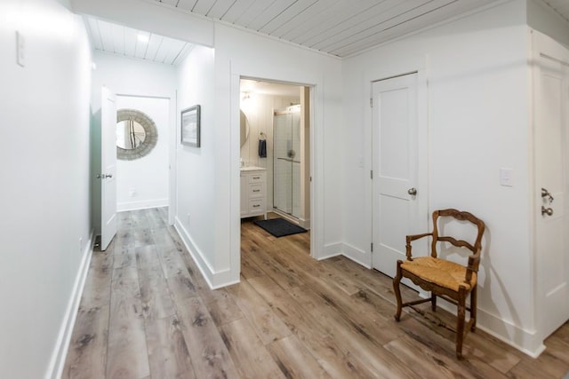 hallway with wood ceiling and light hardwood / wood-style flooring