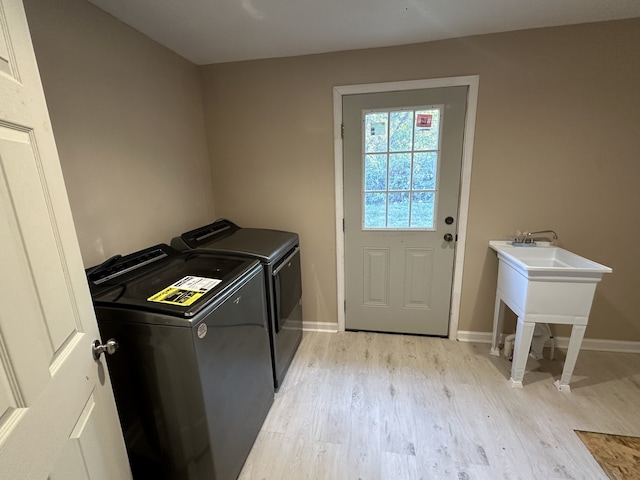 washroom with light hardwood / wood-style flooring and washer and dryer