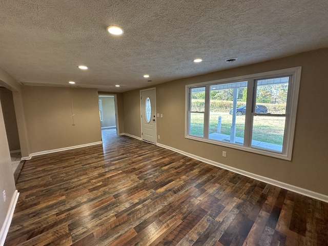 empty room featuring dark wood-type flooring and a textured ceiling