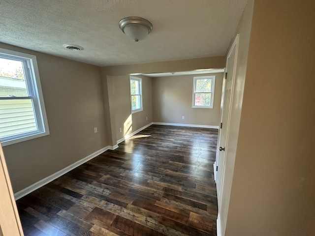 empty room featuring dark hardwood / wood-style floors and plenty of natural light