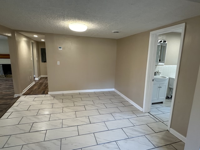 empty room featuring a textured ceiling and sink