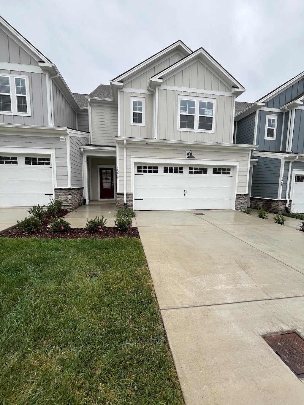 craftsman-style home featuring board and batten siding, stone siding, a garage, and driveway
