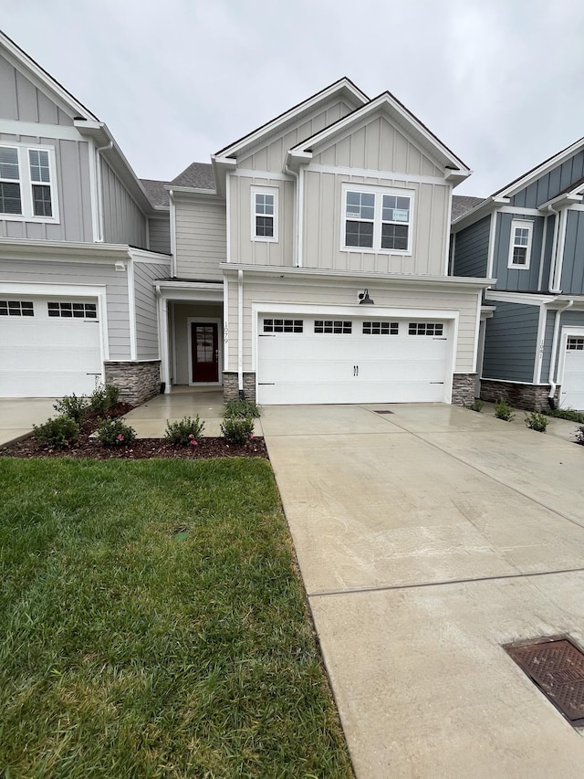 craftsman-style home featuring board and batten siding, stone siding, a garage, and driveway