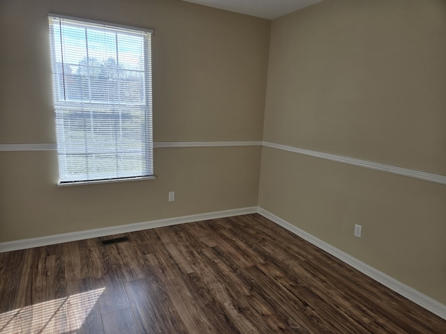 spare room featuring dark wood-type flooring