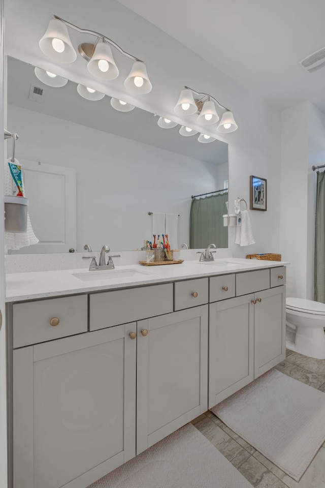 bathroom featuring vanity, toilet, and curtained shower