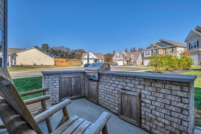 view of patio with area for grilling and a grill