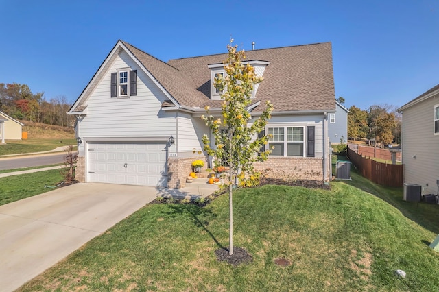 view of front of home featuring a front yard, central AC unit, and a garage