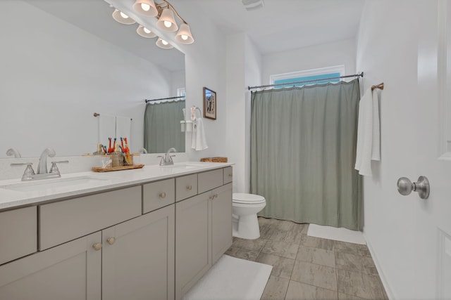 bathroom featuring vanity, curtained shower, and toilet