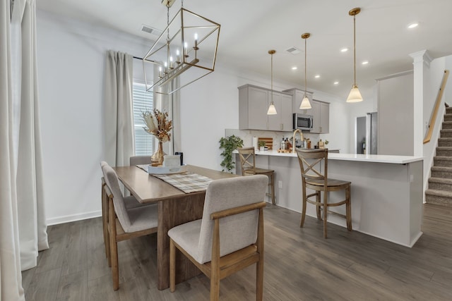 dining area with ornamental molding and dark hardwood / wood-style floors