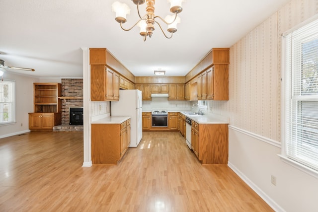 kitchen with decorative light fixtures, light hardwood / wood-style flooring, sink, white appliances, and ceiling fan with notable chandelier