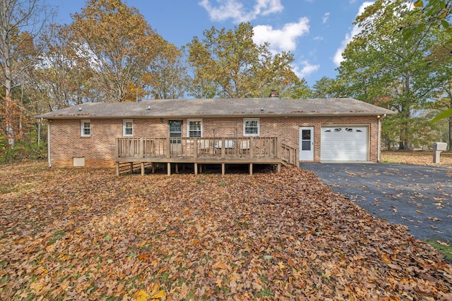 back of property with a garage and a deck