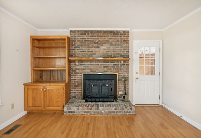 unfurnished living room featuring a wood stove, ornamental molding, and hardwood / wood-style flooring