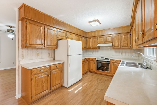 kitchen with stainless steel electric range, light wood-type flooring, white refrigerator, a textured ceiling, and sink